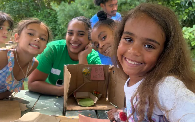 Smiling campers at a craft table