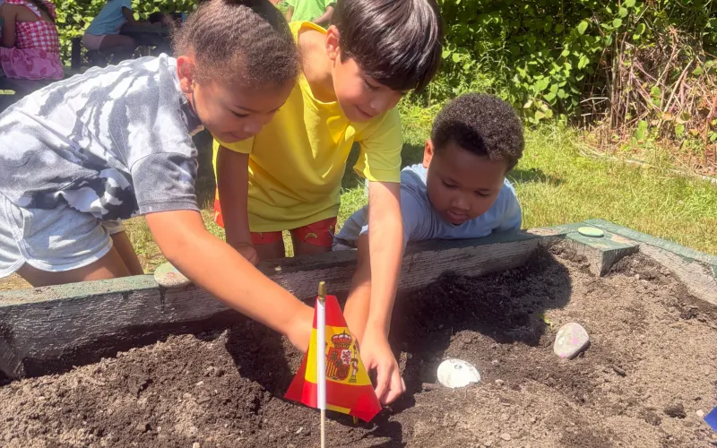Campers planting in a garden bed